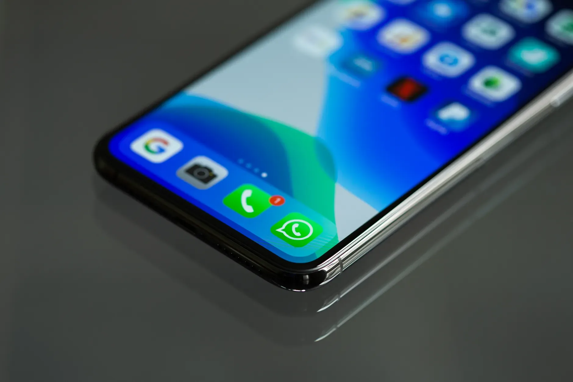 Telemóvel com a app WhatsApp Business aberta sobre o balcão de uma loja, a mostrar uma conversa de atendimento ao cliente