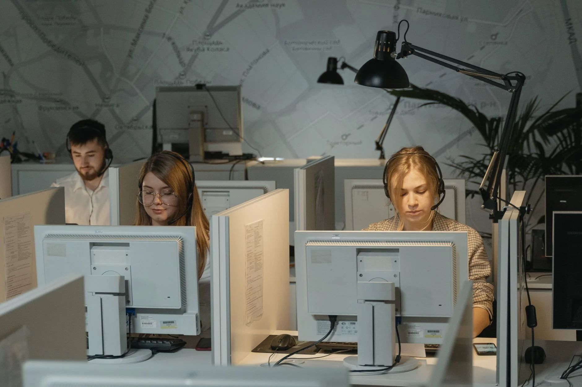 Equipa de atendimento ao cliente a responder mensagens em computadores num escritório